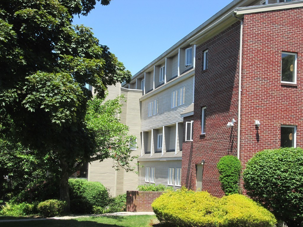 4 Duck Pond Road, Unit 204 Beverly, MA 01915 - Photo 3 of 23 a front view of a building with a garden