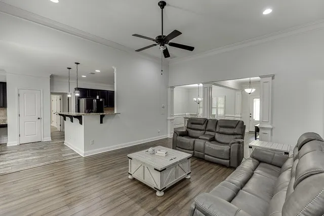 a living room with furniture and a view of kitchen