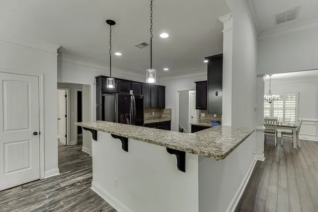 a large kitchen with kitchen island a large island in it