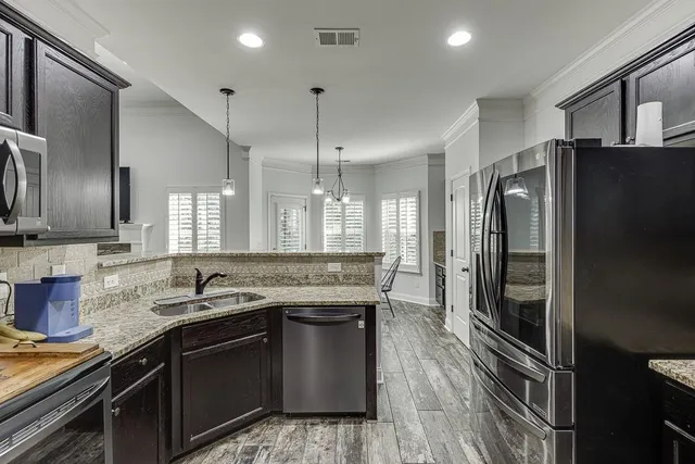 a kitchen with granite countertop a refrigerator stove and sink
