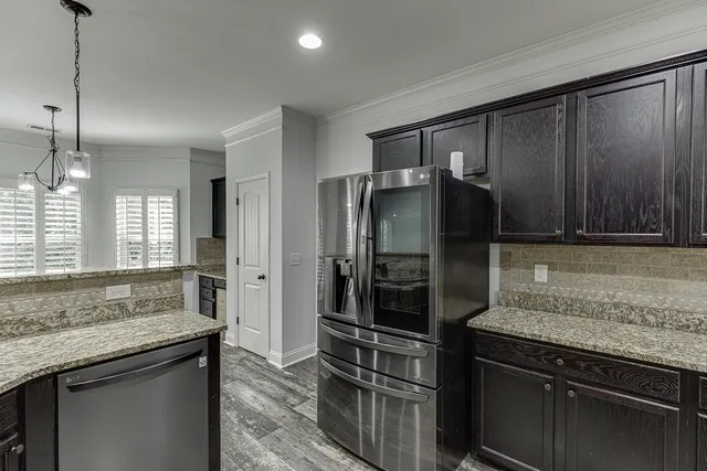 a kitchen with granite countertop a refrigerator and a sink