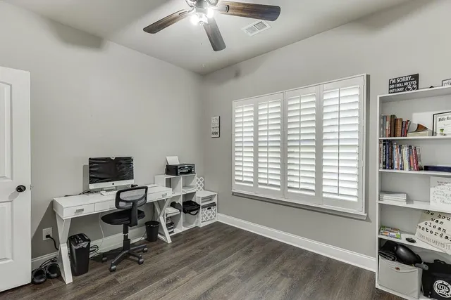 a view of a workspace with furniture and a window