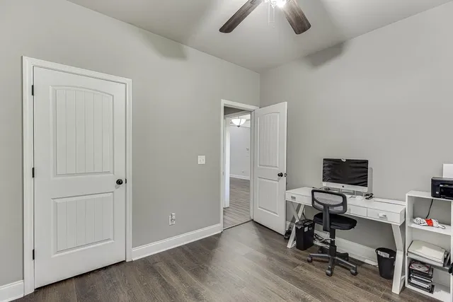 a view of a workspace with furniture and a ceiling fan