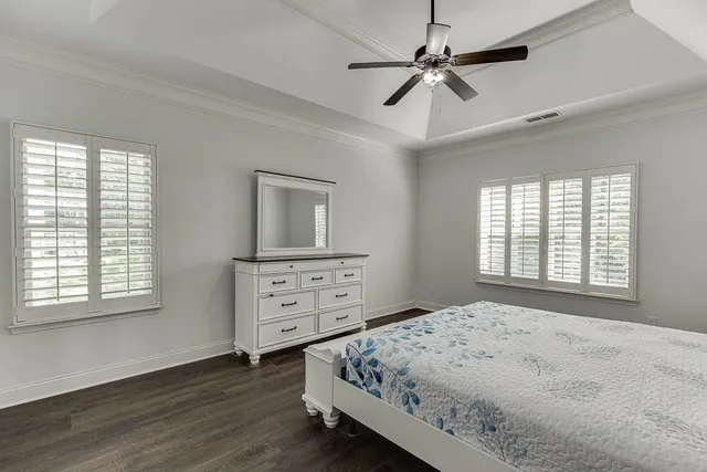 a bedroom with a bed a chandelier and a window