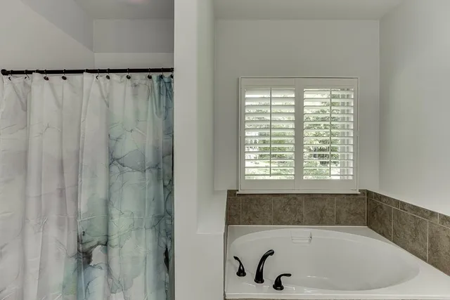 a bathroom with a bathtub and a window