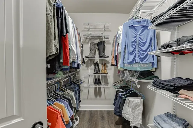 a view of walk in closet with clothes