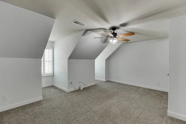a view of an empty room with a ceiling fan and window