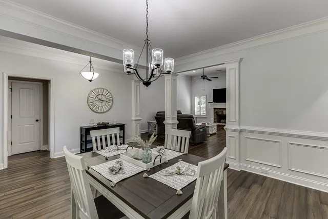 a view of a dining room and livingroom with furniture wooden floor a chandelier