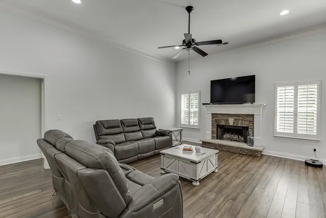 a living room with furniture a fireplace and a flat screen tv