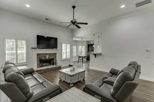 a living room with furniture a fireplace and a flat screen tv