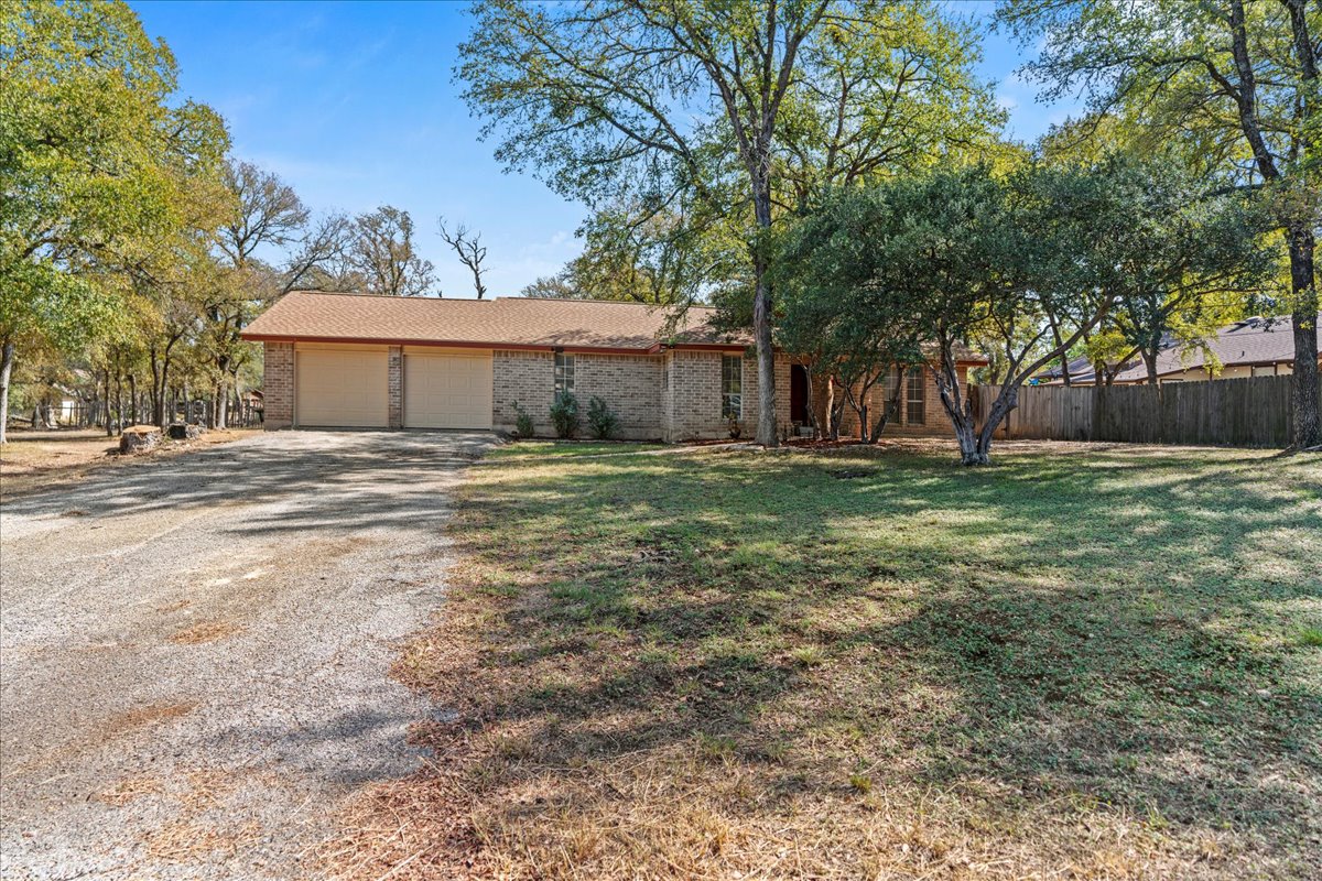 5403 Valencia Court Georgetown, TX 78628 - Photo 14 of 34 a big house with a big yard and large trees
