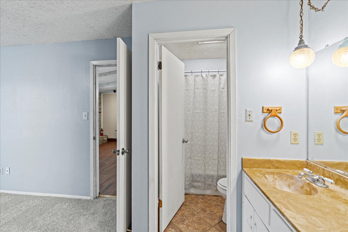 5403 Valencia Court Georgetown, TX 78628 - Photo 16 of 34 a bathroom with a granite countertop sink a toilet and shower