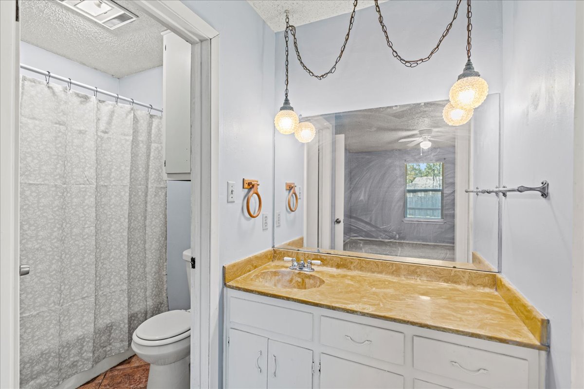 5403 Valencia Court Georgetown, TX 78628 - Photo 17 of 34 a bathroom with a granite countertop sink a toilet and shower