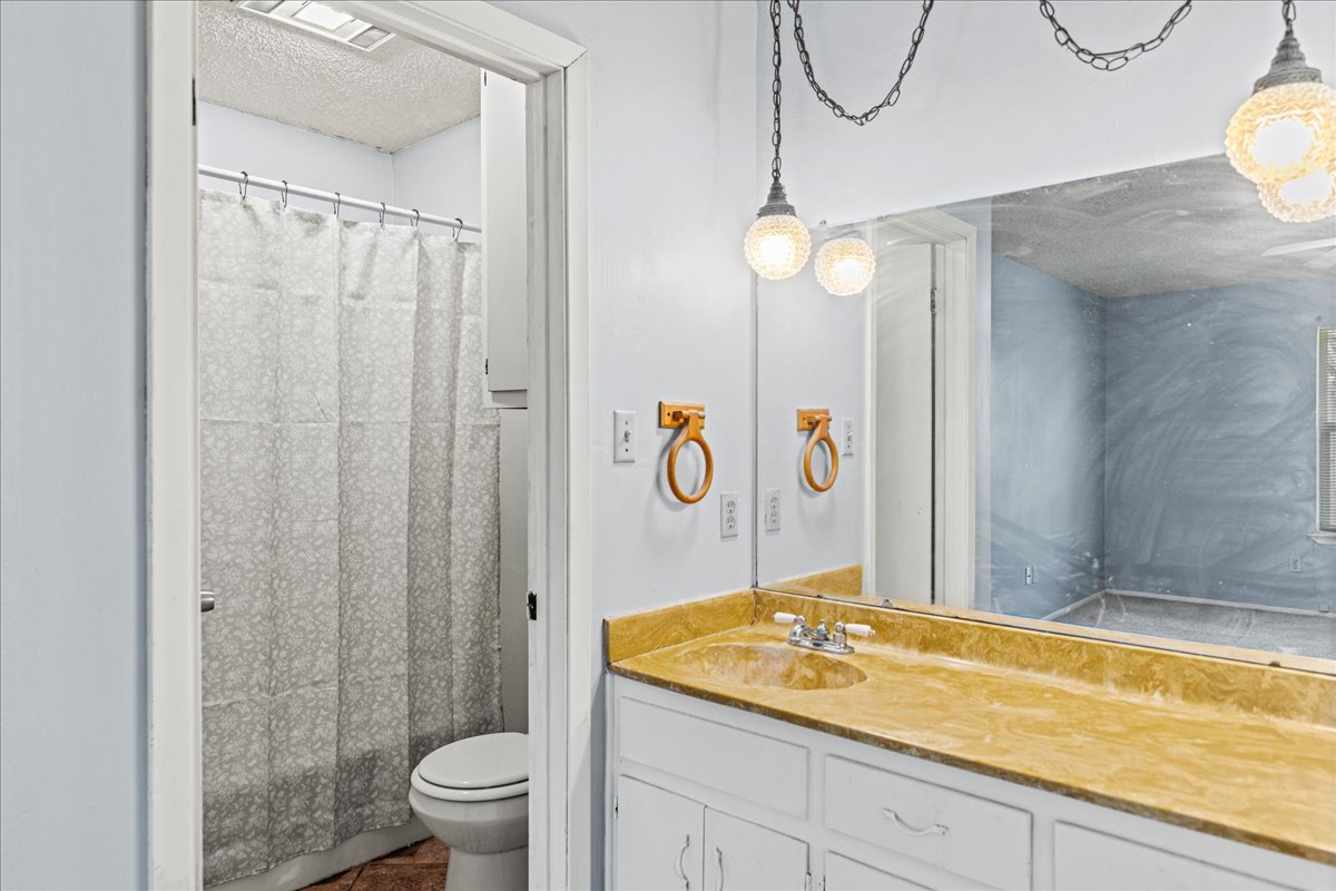 5403 Valencia Court Georgetown, TX 78628 - Photo 27 of 34 a bathroom with a granite countertop sink a toilet and shower