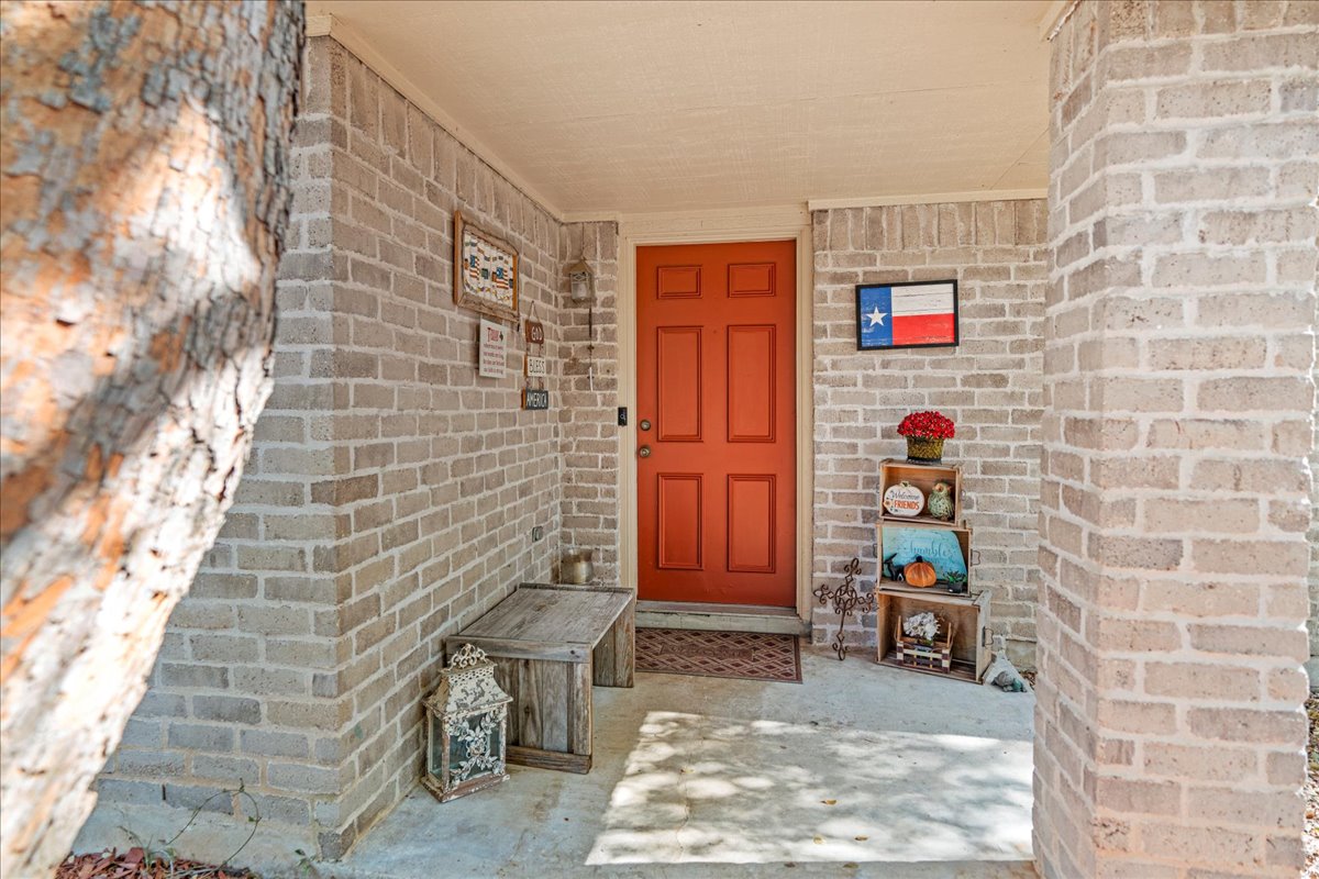 5403 Valencia Court Georgetown, TX 78628 - Photo 4 of 34 a brick building with a bench and a potted plant