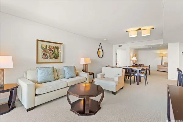 a living room with couches and a dining table with wooden floor