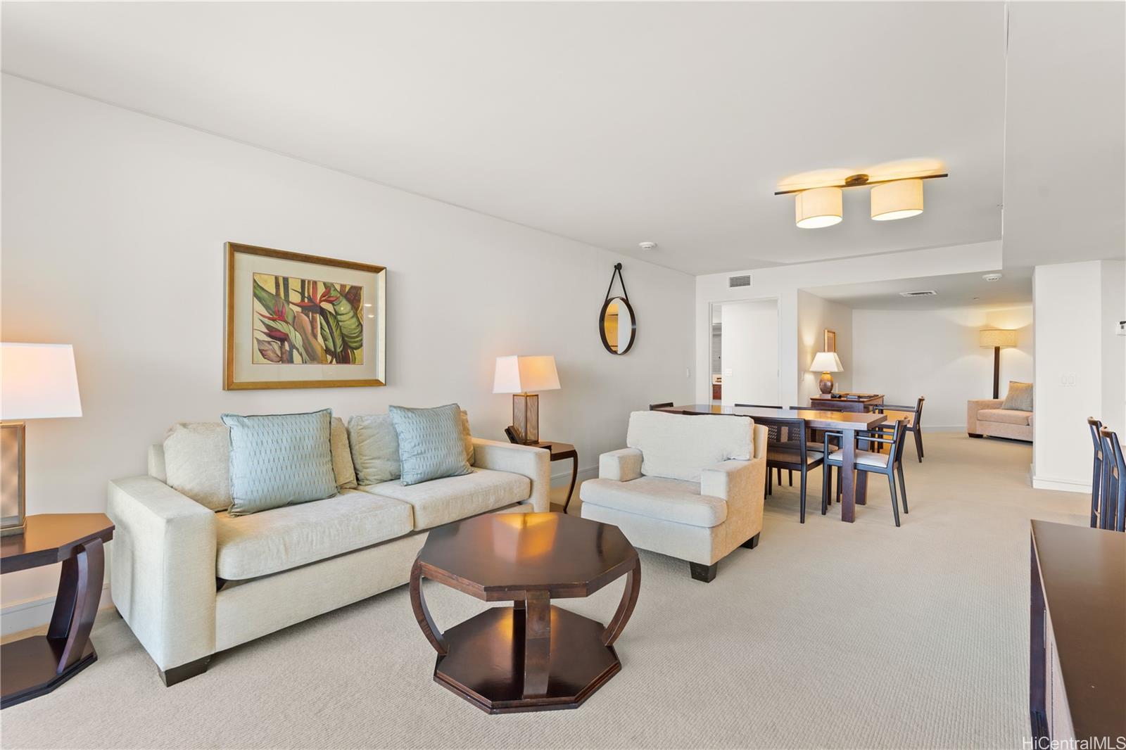 223 Saratoga Road, Unit 1115 Honolulu, HI 96815 - Photo 12 of 25 a living room with couches and a dining table with wooden floor