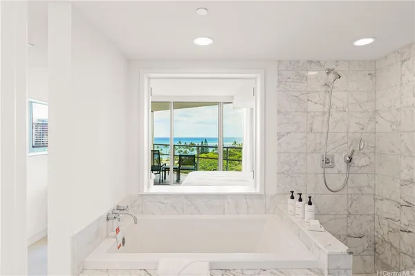 a white bath tub sitting next to a shower