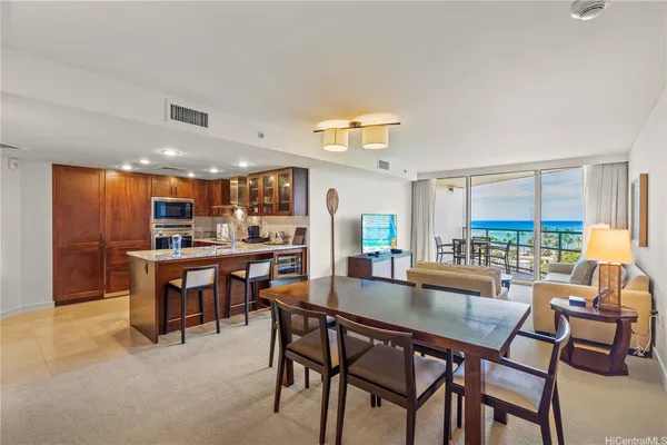 a dining area with furniture and a floor to ceiling window