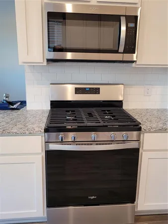 a stove top oven sitting inside of a kitchen