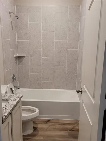 a bathroom with a granite countertop toilet a sink and bathtub