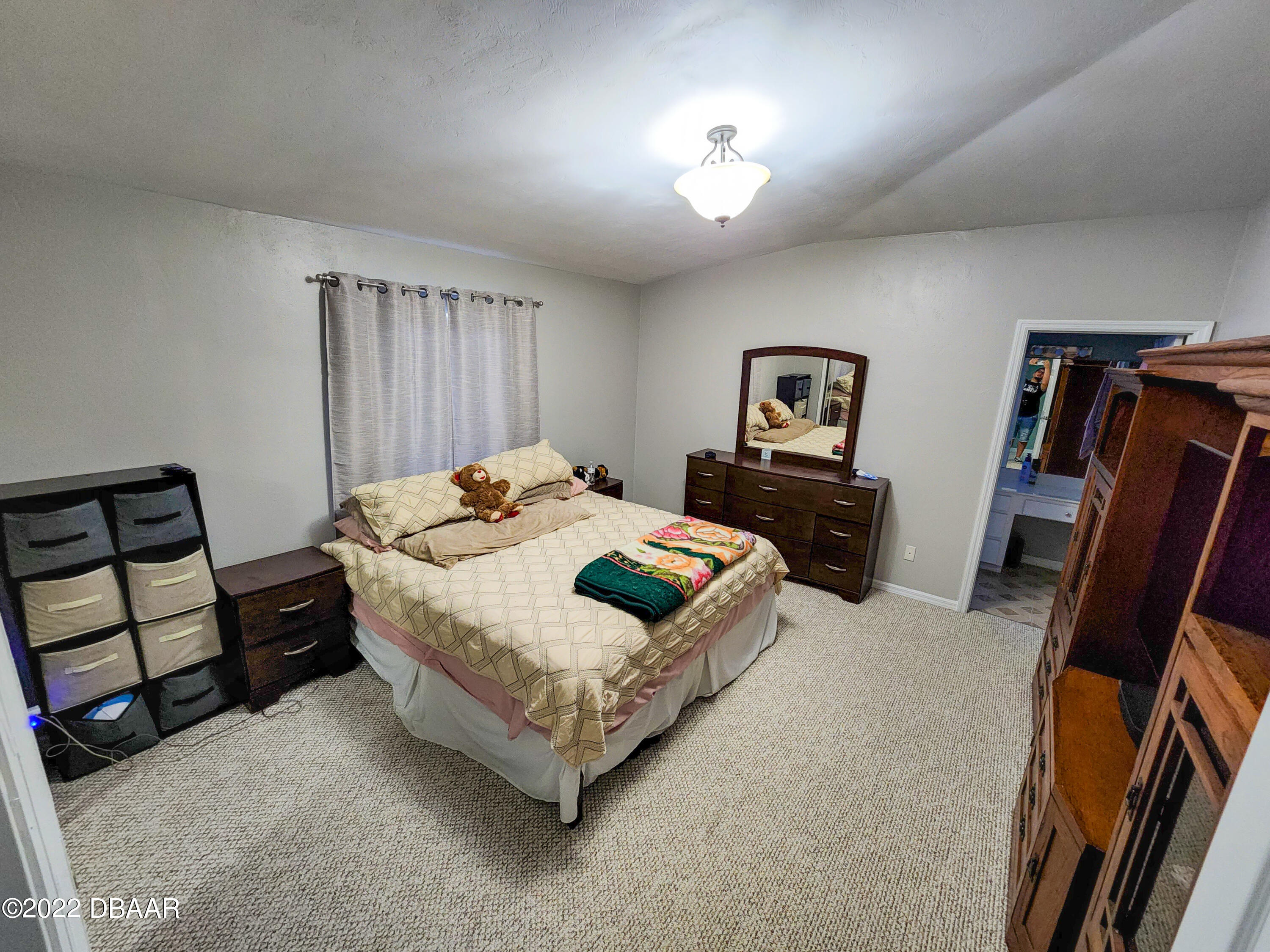1467 Bay Grove Drive Port Orange, FL 32129 - Photo 24 of 35 a bedroom with a bed and a flat tv screen on dresser