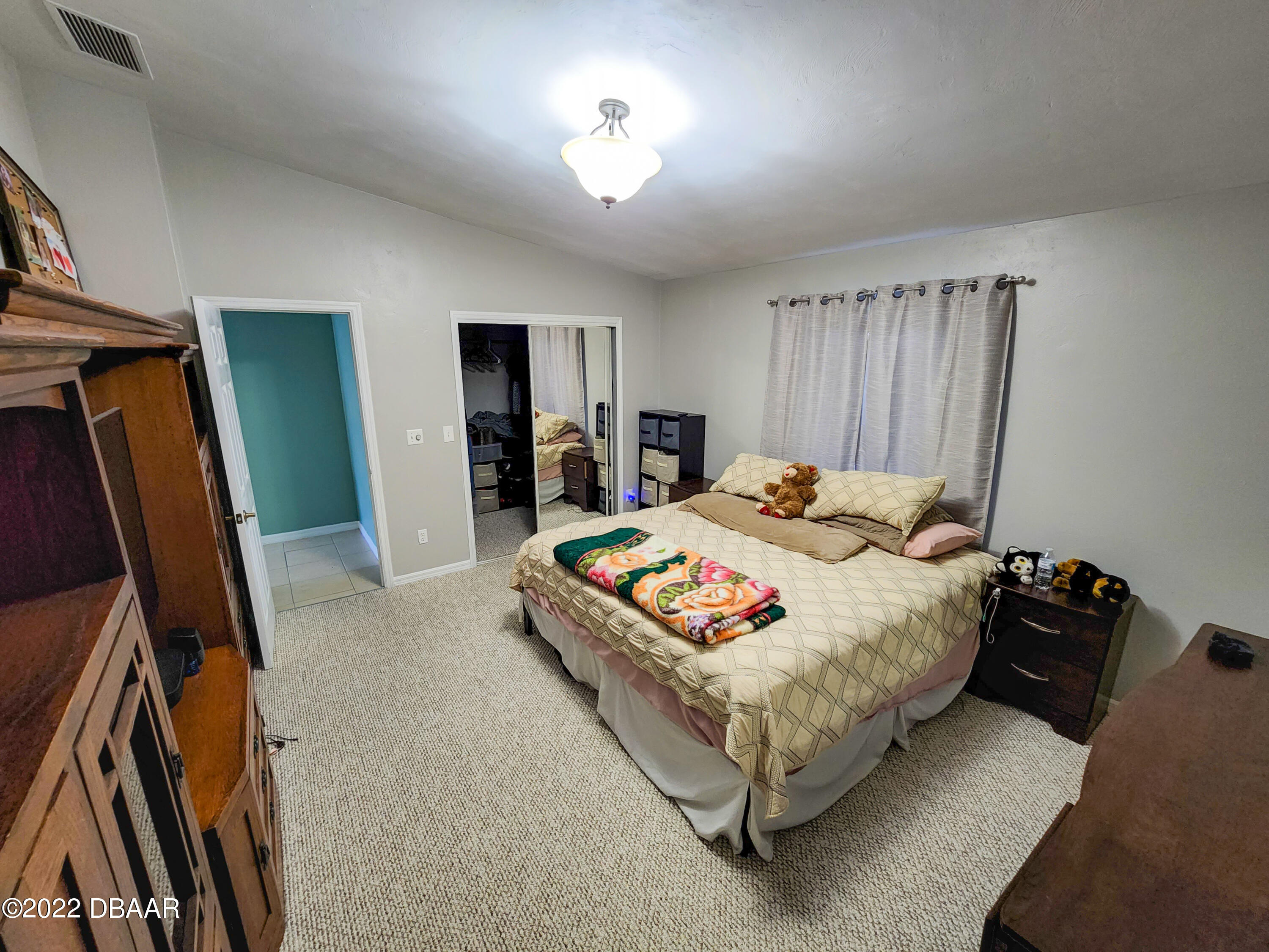 1467 Bay Grove Drive Port Orange, FL 32129 - Photo 25 of 35 a bedroom with a bed and a flat tv screen on the dresser