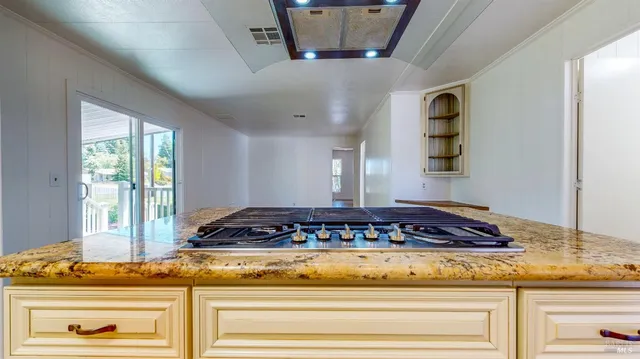 a kitchen with stainless steel appliances granite countertop a stove a sink and a refrigerator