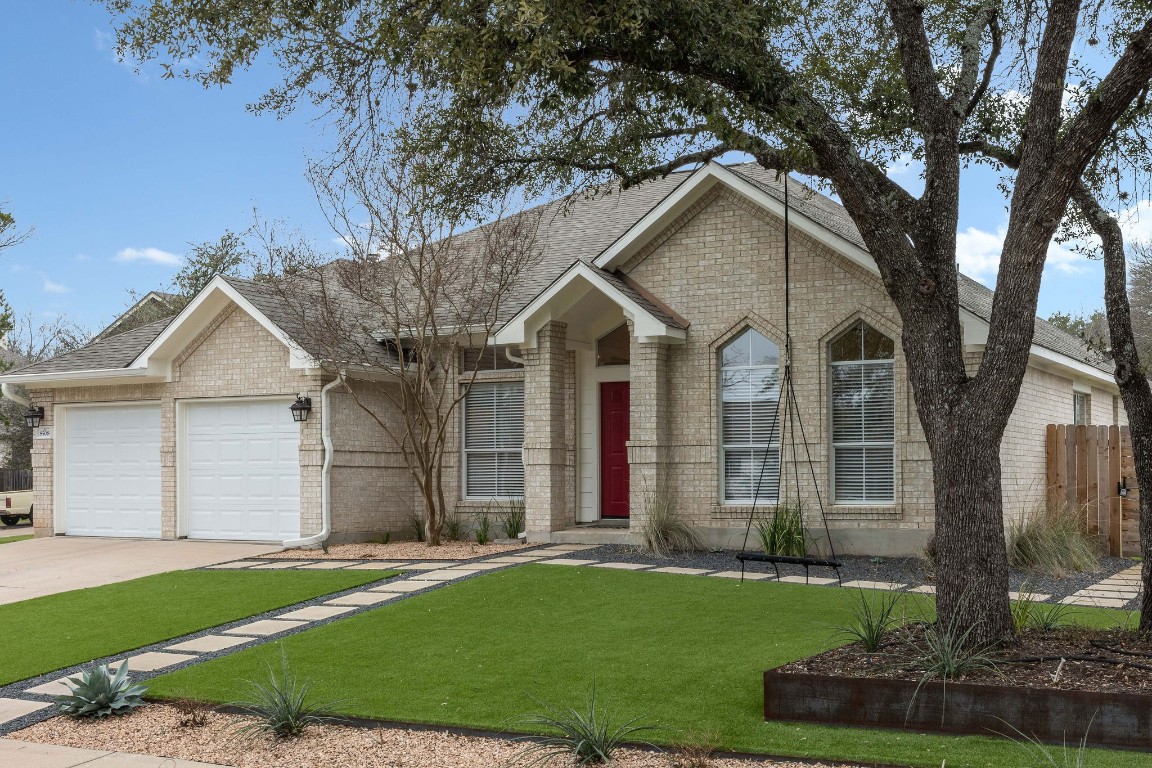 a view of a white house next to a yard with big trees