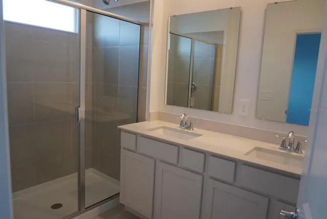 a bathroom with a shower sink and mirror