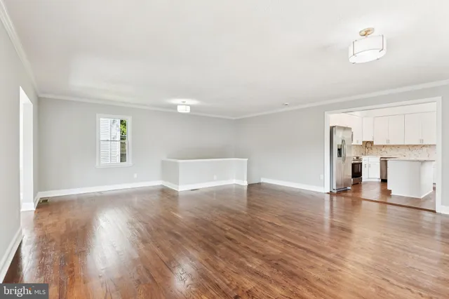 a view of empty room with wooden floor