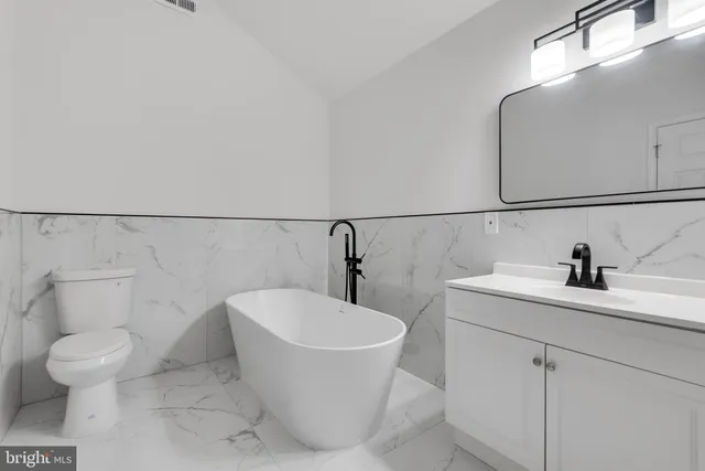 a white bath tub sitting next to a white toilet