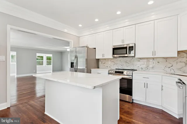 a kitchen with stainless steel appliances granite countertop a stove a sink and a refrigerator