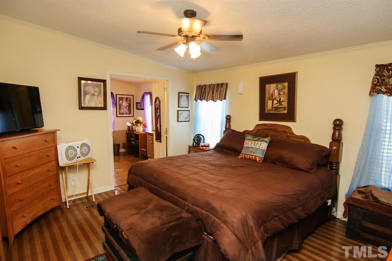 5699 Elevation Road Benson, NC 27504 - Photo 14 of 24 a bedroom with a bed and dresser