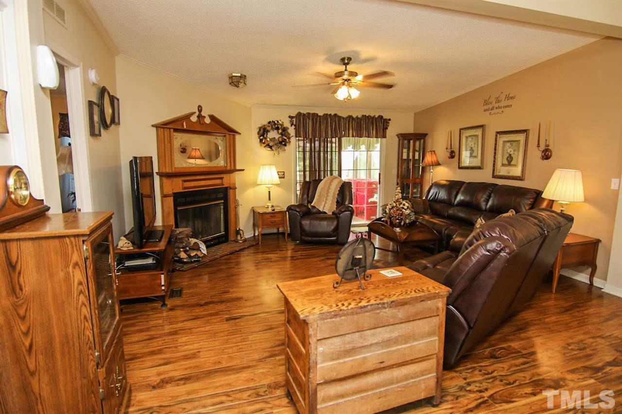 5699 Elevation Road Benson, NC 27504 - Photo 5 of 24 a living room with furniture a fireplace and a flat screen tv
