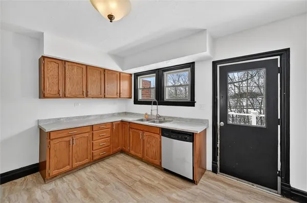 a kitchen with stainless steel appliances granite countertop a sink and a stove next to a window