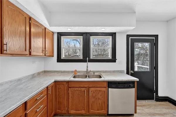 a kitchen with stainless steel appliances granite countertop a sink and cabinets with wooden floor