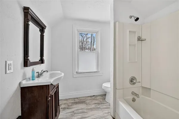 a bathroom with a tub sink and mirror
