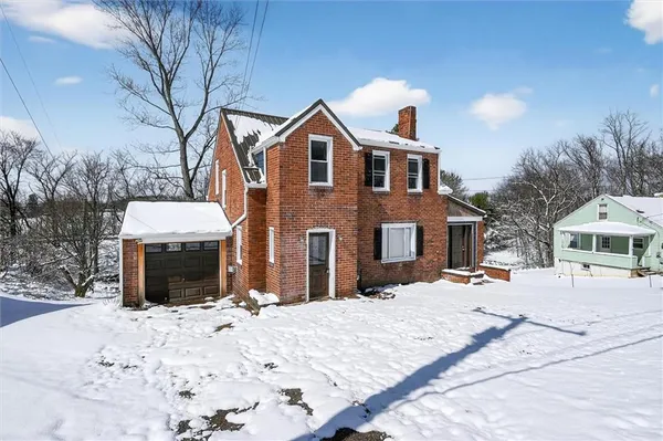 a front view of a house with a yard covered in snow