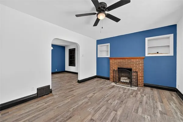 a view of empty room with wooden floor and fireplace