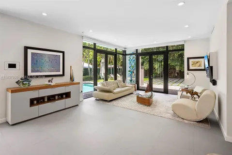 a living room with furniture and floor to ceiling windows