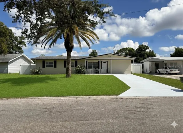 a front view of a house with a garden and trees