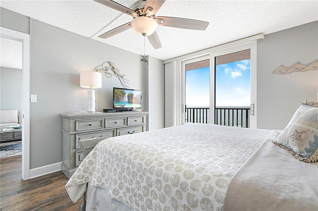 15316 Gulf Boulevard, Unit 402 Madeira Beach, FL 33708 - Photo 17 of 41 a bedroom with a bed and a flat screen tv