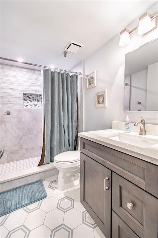 15316 Gulf Boulevard, Unit 402 Madeira Beach, FL 33708 - Photo 23 of 41 a bathroom with a granite countertop sink toilet and shower