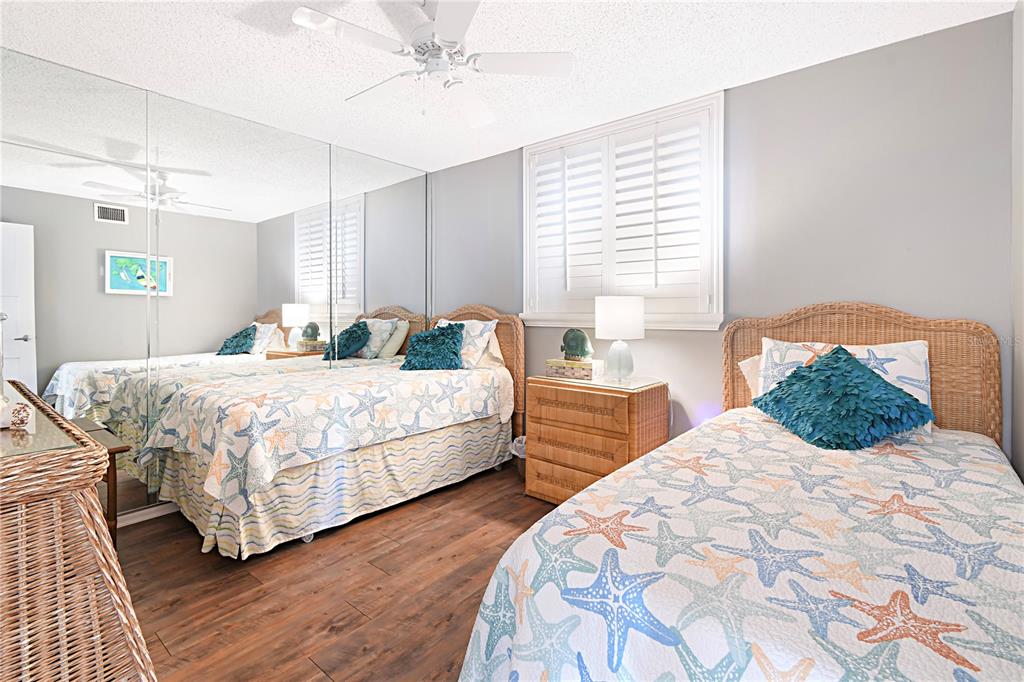 15316 Gulf Boulevard, Unit 402 Madeira Beach, FL 33708 - Photo 24 of 41 a bedroom with a bed and wooden floor