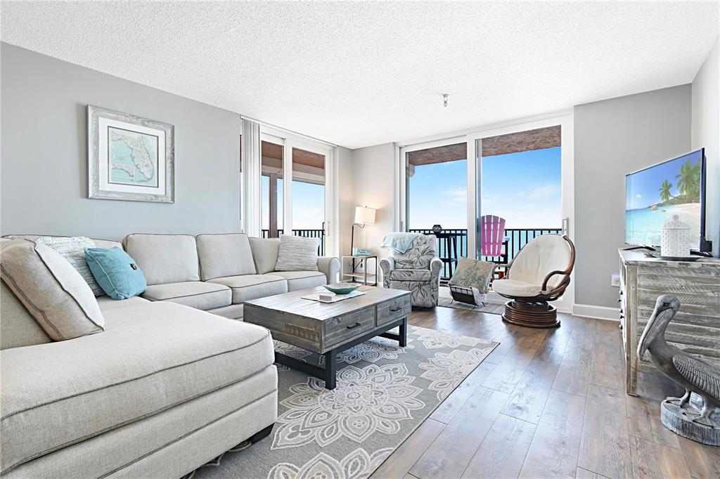 15316 Gulf Boulevard, Unit 402 Madeira Beach, FL 33708 - Photo 4 of 41 a living room with furniture and wooden floor