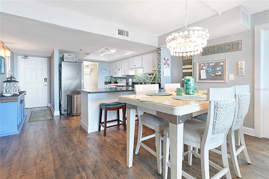 15316 Gulf Boulevard, Unit 402 Madeira Beach, FL 33708 - Photo 9 of 41 a dining room with wooden floor and chandelier