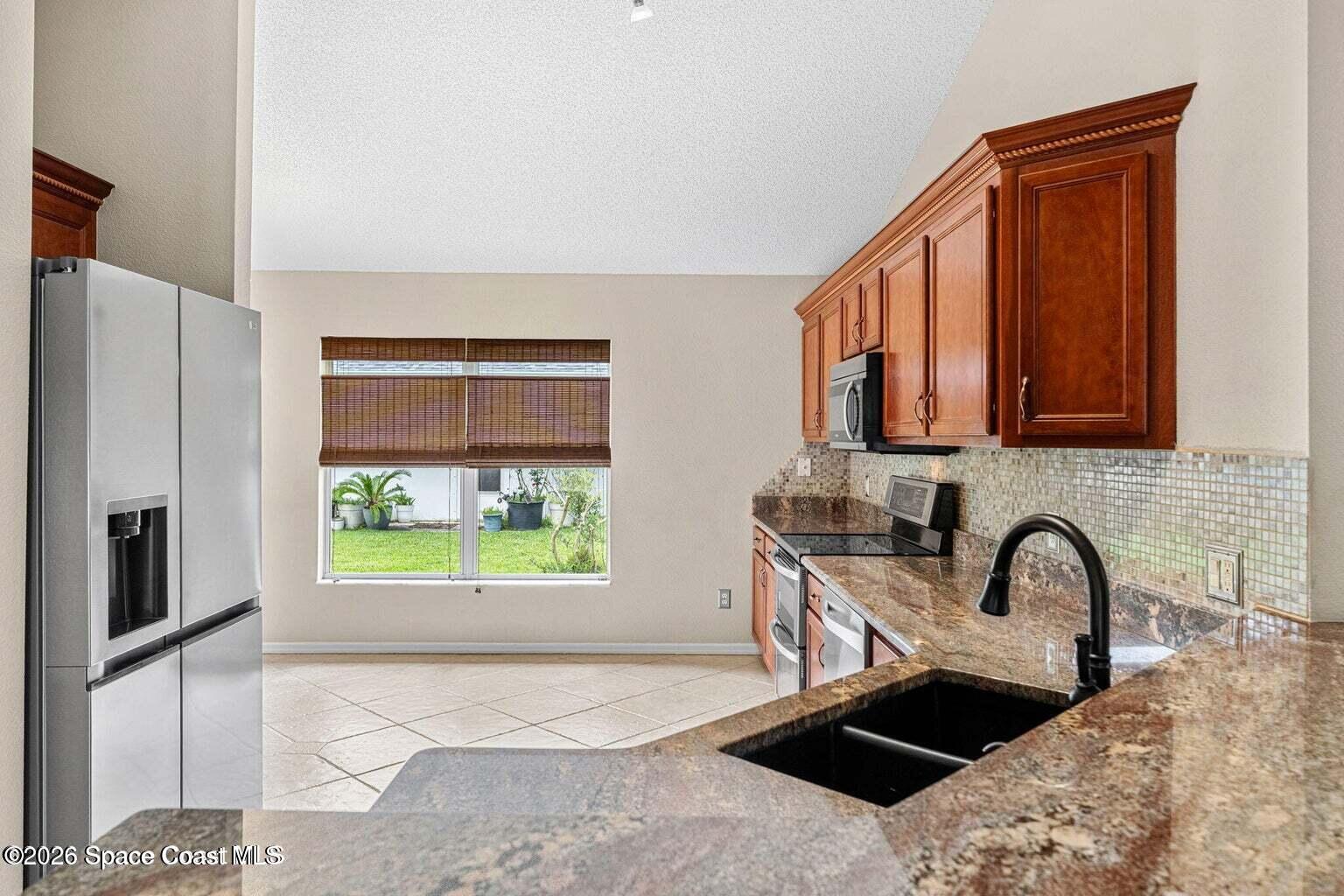 4741 Decatur Circle Melbourne, FL 32934 - Photo 10 of 44 a kitchen with stainless steel appliances granite countertop a stove a sink and a refrigerator