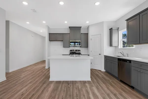 a kitchen with a sink cabinets stainless steel appliances and a window