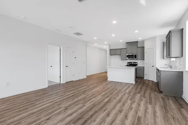 a view of kitchen with granite countertop cabinets and refrigerator